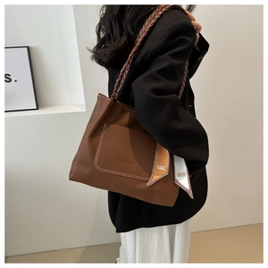 Braune Shopper-Tasche aus Leder mit gewebtem Riemen und Seidenschal am Modell