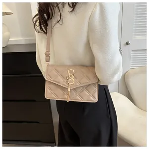 Nahaufnahme der beige gesteppten Umhängetasche mit goldener Quaste und Metall-Logo