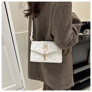 Detail der weißen Stepptasche mit goldenem SS-Logo und Quaste an der Schulter des Models