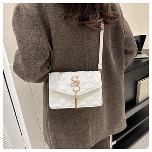 Detailansicht weiße gesteppte Umhängetasche mit goldenem Logo und langer Quaste