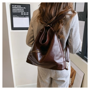 Gros plan sur la texture du cuir marron foncé et du zip métallique du sac fourre-tout