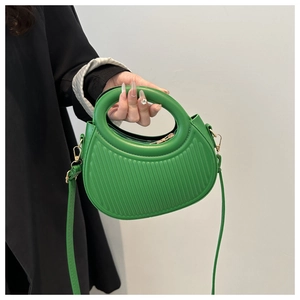 Détail du sac croissant vert émeraude avec texture à rayures et poignée ronde