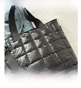 Detalle de la textura acolchada negra y el anillo en D metálico del bolso tipo tote