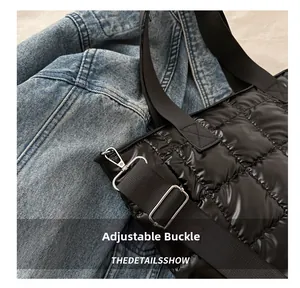 Detalle de la hebilla de metal ajustable y cierre de mosquetón en bolso acolchado negro