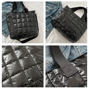 Detalle del bordado del bolso tote acolchado negro con asas y correa ajustable ancha