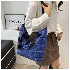 Detalle del bolso tote acolchado azul eléctrico con acabado metálico y correa ancha