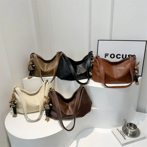 Retro wax leather tote bags in five colors with a cute bear charm on a white stand