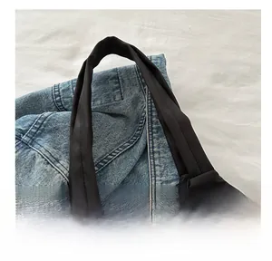 Gros plan sur les poignées larges renforcées et les coutures d'un sac cabas noir chic