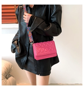 Detail of rose pink crossbody bag with geometric quilting and ethnic woven strap