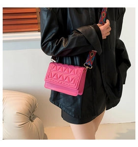 Detail of rose pink quilted crossbody bag with stylish geometric pattern wide strap
