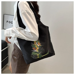 Détail du grand sac cabas noir avec imprimé oiseau de paradis et motifs floraux