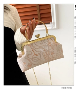 Dettaglio dell'elegante borsa ricamata color champagne con cervo e manico dorato