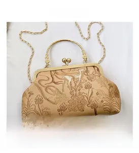 Dettaglio della borsa jacquard vintage con manico in metallo dorato e chiusura decorata