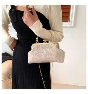 Dettaglio borsa vintage in jacquard con motivi floreali di cervo e chiusura in oro