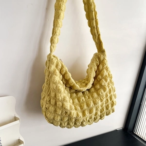 Detail of yellow bubble textured cloud bag showing the popcorn pleated fabric and large capacity
