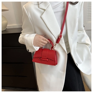 Mini sac bandoulière rouge en cuir grainé avec détails métalliques dorés sur modèle