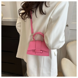 Détail d'un sac à main trapèze rose vif avec cuir grainé et bandoulière réglable