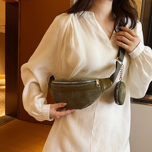 Sac banane en velours côtelé vert foncé avec pochette ronde, porté par un mannequin chic