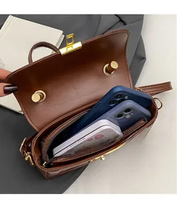Interno della borsa a tracolla marrone scuro con scomparto principale e tasca a zip