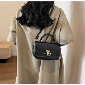 Vista posteriore di una modella in trench beige con borsa a tracolla chic in pelle nera