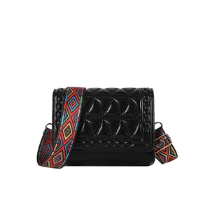 Quilted black crossbody bag with a colorful ethnic patterned wide shoulder strap for women