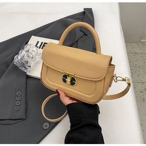 Dettaglio della borsa a tracolla beige-marrone con chiusura dorata e texture in pelle