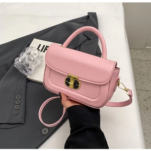 Dettaglio della borsa rosa con chiusura a scatto ovale dorata e finitura in pelle opaca
