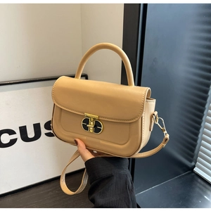 Dettaglio borsa beige in pelle PU con chiusura rotante dorata e manico superiore