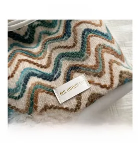 Detail of wool tote bag showing wave pattern weaving and white leather brand label