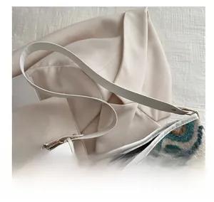 Detail of knit water ripple pattern and white leather strap on lady bucket bag