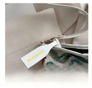 Detailed macro view of tricolor wave knit fabric and leather tag on this bucket bag