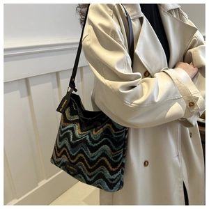 Detail shot of wavy textured bucket bag with leather strap and MS.HUIXIBAG brand tag