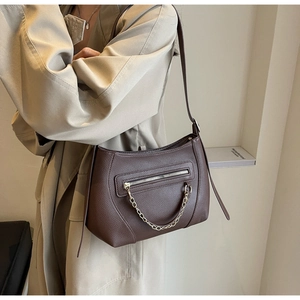 Detail of coffee brown crossbody bag with lychee texture and decorative chain strap