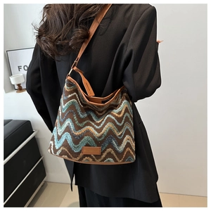 Close-up of retro wave pattern knit fabric and brown leather strap on a bucket bag