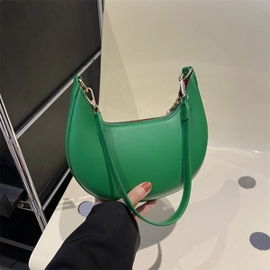 Sac baguette minimaliste vert vif avec doublure rouge et accessoires dorés élégants