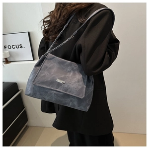 Detail of grey marble pattern tote bag featuring silver chain strap and metal logo plate