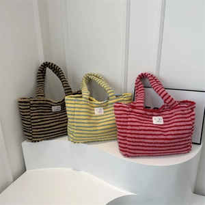 Striped plush tote bag in faux shearling featuring black, blue, and red color patterns