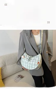 Close-up of mint green tweed hobo bag with textured fabric and orange fashion label