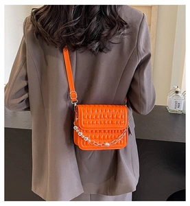 Détail du mini sac bandoulière matelassé orange avec chaîne à perles argentées