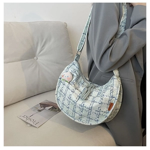 Detail of blue and white checkered tweed moon bag with fashion tag and peach pin