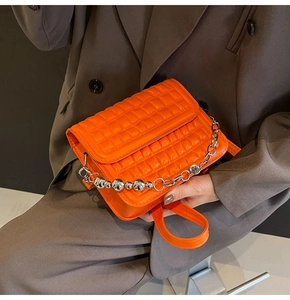 Détail du sac bandoulière matelassé orange avec chaîne à billes et sangle en cuir