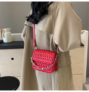 Détail du sac bandoulière rouge matelassé avec chaîne à billes argentée et similicuir