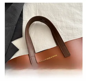 Close-up of brown tote bag with high-quality stitching and gold fashion lettering