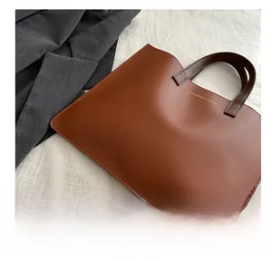 Detail view of the brown leather briefcase with gold fashion lettering and fine stitching