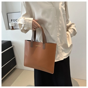 Close-up of caramel tote bag with golden FASHION & BAGS text and dark brown handles