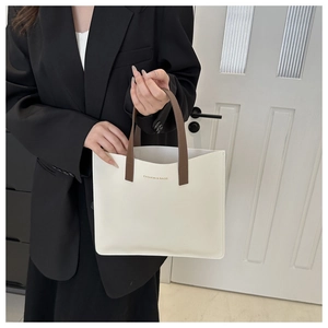 Detail of minimalist cream tote bag with brown straps and FASHION & BAGS lettering