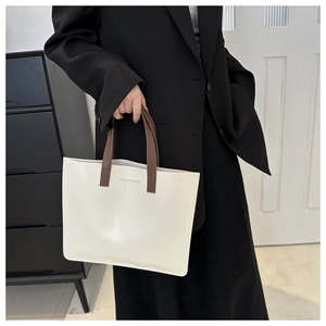 Detail of minimalist cream tote bag with brown handles and FASHION & BAGS printed text