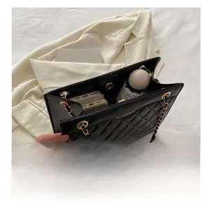 Internal capacity of black quilted leather shoulder bag with gold chain and metal buckle