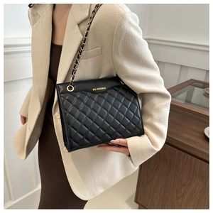 Detail of black quilted leather shoulder bag featuring gold chain strap and brand logo