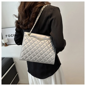 Silver quilted leather shoulder bag with chain strap shown on model for a stylish look
